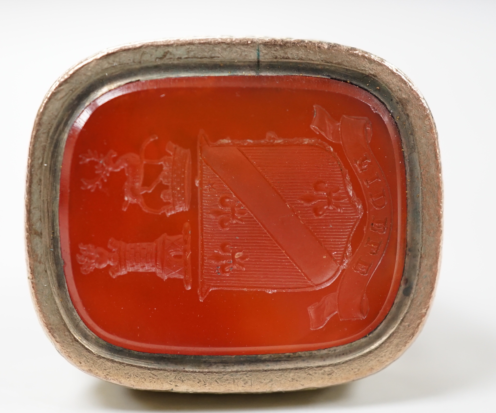 A Georgian yellow metal overlaid and carnelian set fob seal, the matrix carved with a crest, 30mm.